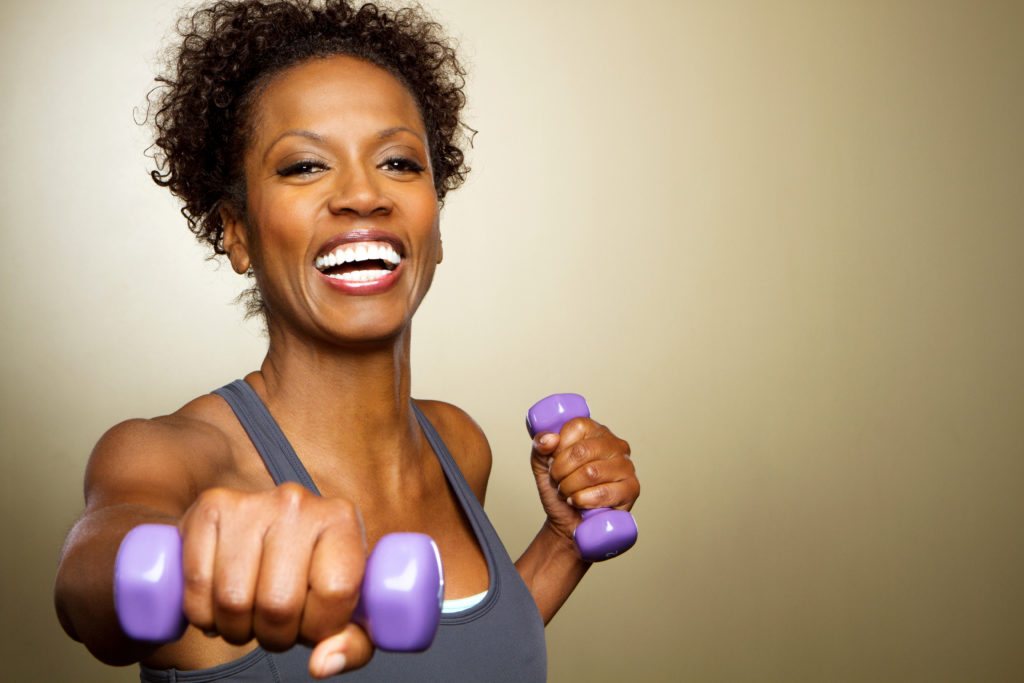 Happy,African,American,Fitness,Woman,Lifting,Dumbbells,Smiling,And,Energetic.